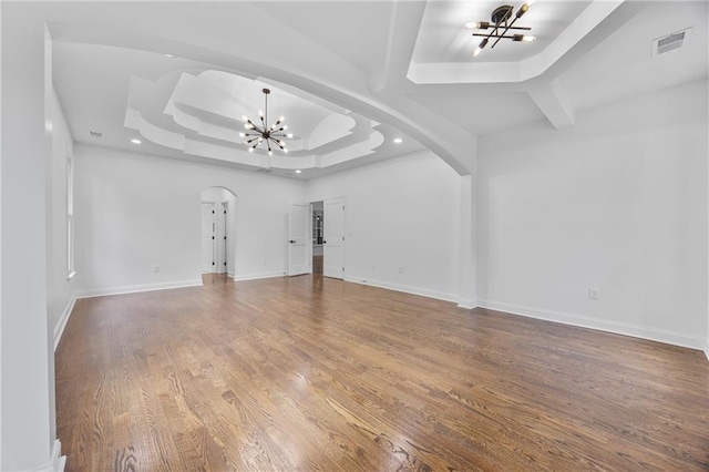 1217 Cabin Bridge Rd, Bethlehem, GA 30620 - unfurnished living room with a chandelier, arched walkways, a raised ceiling, wood finished floors, and baseboards