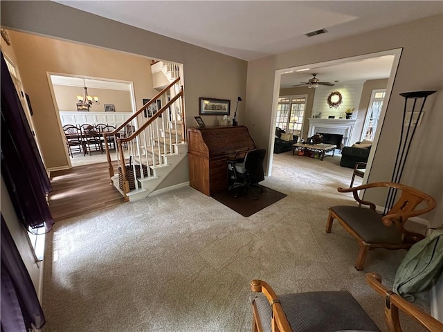 3962 Fox Glen Dr, Woodstock, GA 30189 - living room with a fireplace, carpet, a chandelier, and stairway
