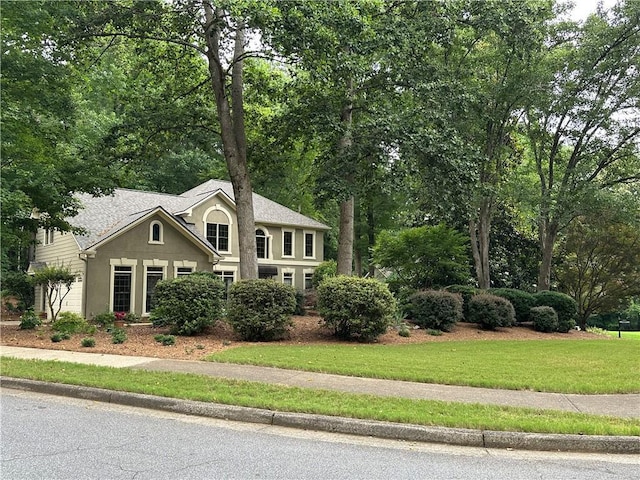 3962 Fox Glen Dr, Woodstock, GA 30189 - traditional home with stucco siding, a front lawn, and view of wooded area