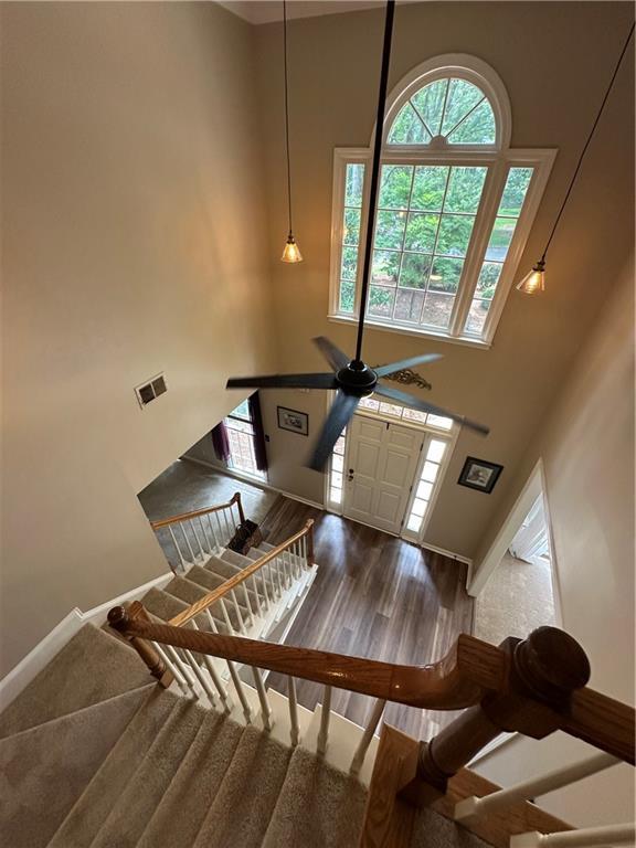 3962 Fox Glen Dr, Woodstock, GA 30189 - stairway with a towering ceiling, healthy amount of natural light, wood finished floors, and a ceiling fan