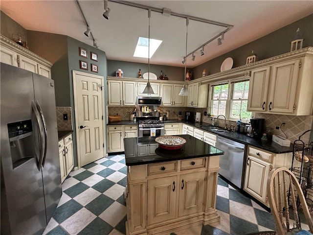 3962 Fox Glen Dr, Woodstock, GA 30189 - kitchen featuring appliances with stainless steel finishes, track lighting, light floors, and cream cabinetry