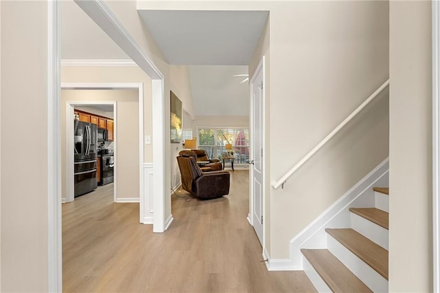 foyer with ornamental molding and light wood-type flooring