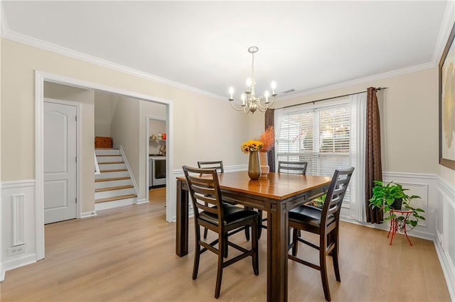 dining room featuring light hardwood / wood-style floors, ornamental molding, and a chandelier