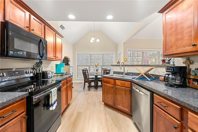 kitchen with lofted ceiling, black appliances, sink, light hardwood / wood-style floors, and a chandelier