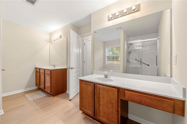 bathroom featuring wood-type flooring, vanity, and a shower with shower door