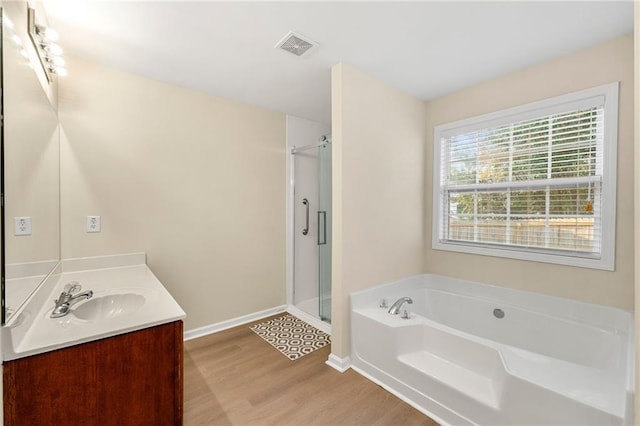 bathroom featuring hardwood / wood-style floors, vanity, and independent shower and bath