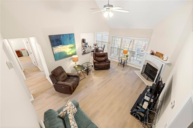 living room with ceiling fan, wood-type flooring, and lofted ceiling