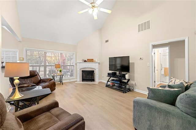 living room featuring light wood-type flooring, high vaulted ceiling, and ceiling fan