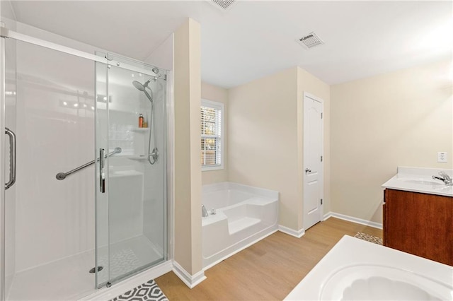 bathroom featuring vanity, shower with separate bathtub, and hardwood / wood-style flooring