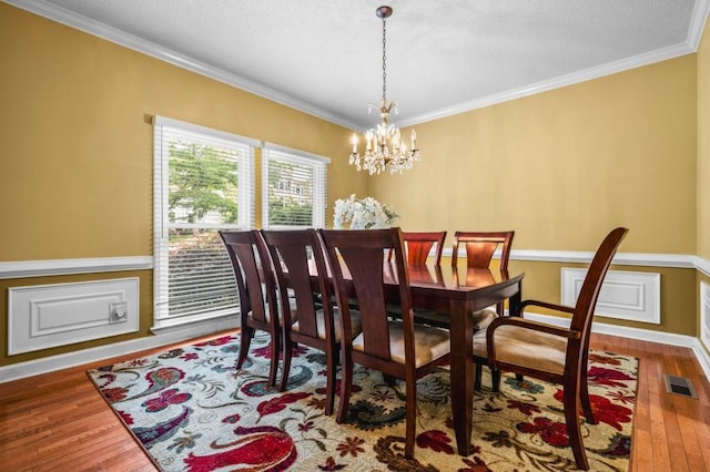 2610 Chadwick Rd, Marietta, GA 30066 - dining space with crown molding, wood finished floors, a chandelier, baseboards, and a textured ceiling