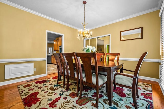 2610 Chadwick Rd, Marietta, GA 30066 - dining space featuring crown molding, wood finished floors, a chandelier, and baseboards