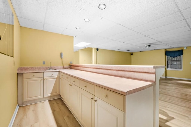 2610 Chadwick Rd, Marietta, GA 30066 - kitchen featuring a peninsula, light wood-type flooring, light countertops, a sink, and baseboards