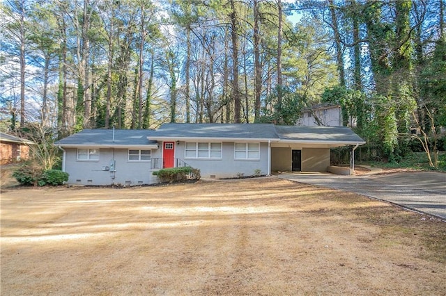 ranch-style home with a carport, crawl space, and driveway