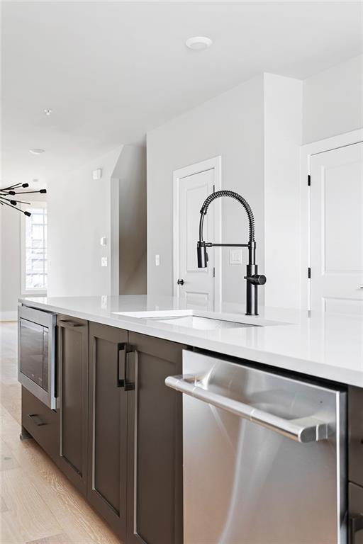 7210 Summit Pl, Alpharetta, GA 30009 - kitchen featuring appliances with stainless steel finishes, light countertops, light wood finished floors, and a sink
