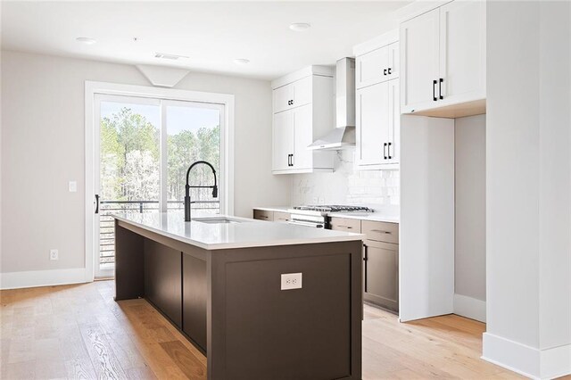7210 Summit Pl, Alpharetta, GA 30009 - kitchen with wall chimney range hood, a sink, light wood-style floors, and baseboards