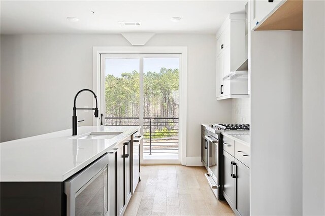 7210 Summit Pl, Alpharetta, GA 30009 - kitchen featuring stainless steel gas stove, a sink, light wood finished floors, plenty of natural light, and recessed lighting