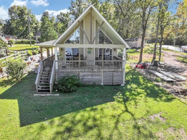 rear view of property with a wooden deck and a lawn