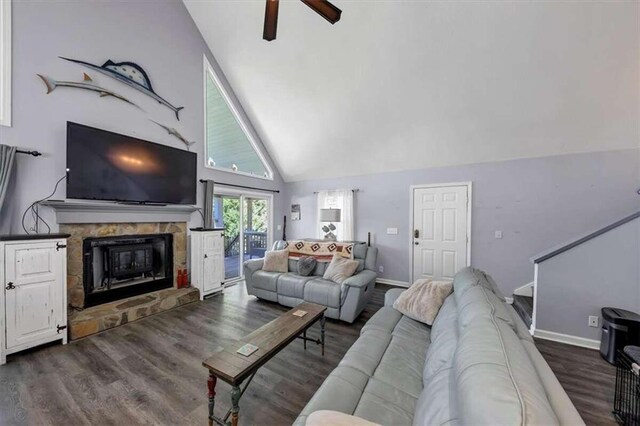 living room with a stone fireplace, ceiling fan, high vaulted ceiling, and dark hardwood / wood-style flooring