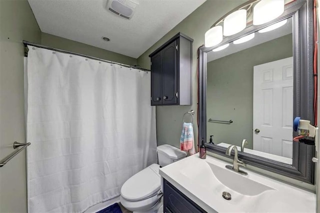 bathroom featuring toilet, a textured ceiling, a shower with curtain, and vanity