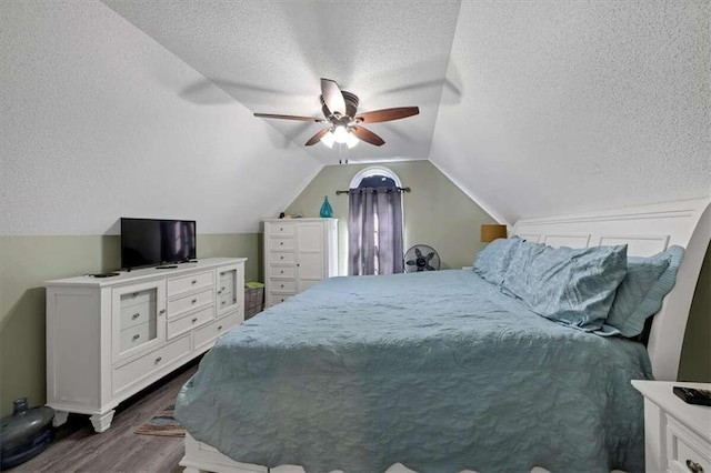 bedroom featuring dark hardwood / wood-style flooring, lofted ceiling, a textured ceiling, and ceiling fan