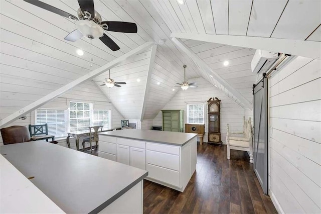 kitchen featuring a wealth of natural light, a center island, a barn door, and white cabinets