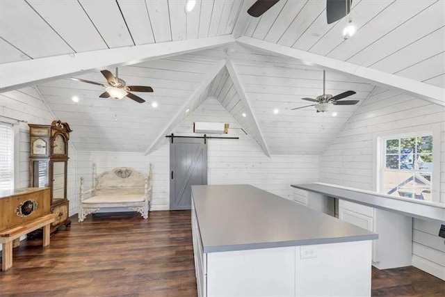 interior space with dark hardwood / wood-style flooring, a barn door, wooden ceiling, vaulted ceiling, and wooden walls