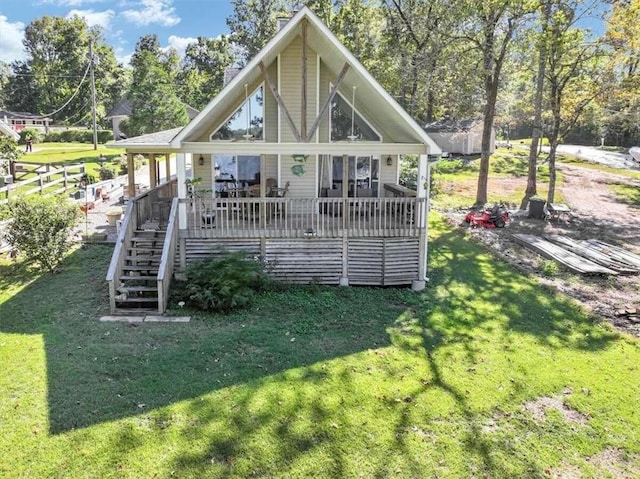 rear view of house with a wooden deck and a lawn