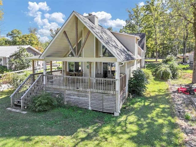 back of house with a wooden deck and a lawn