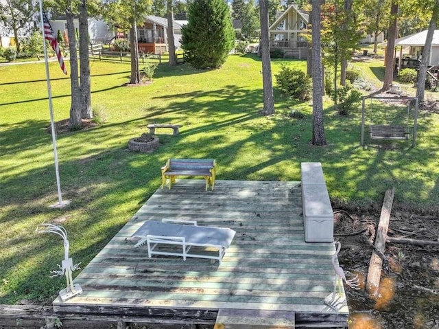 view of home's community with a wooden deck and a yard