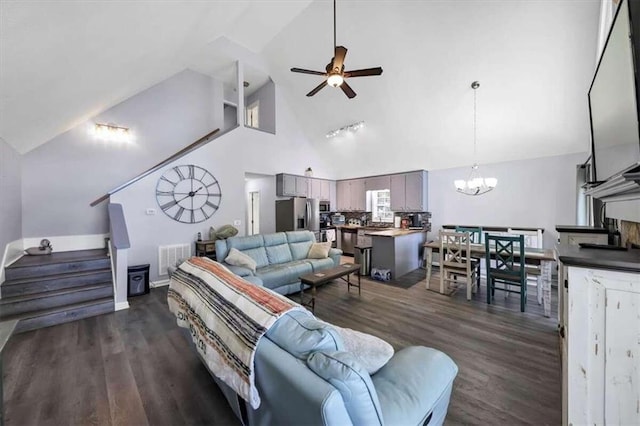 living room with ceiling fan with notable chandelier, dark hardwood / wood-style floors, and high vaulted ceiling