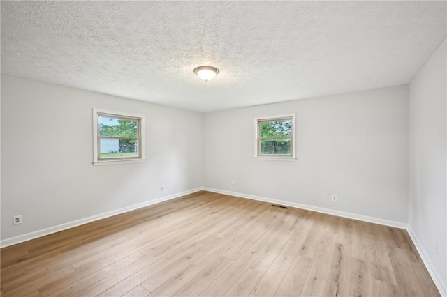 empty room with plenty of natural light and light wood-style flooring
