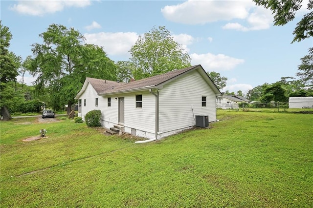 view of side of home featuring a yard, central AC unit, and entry steps