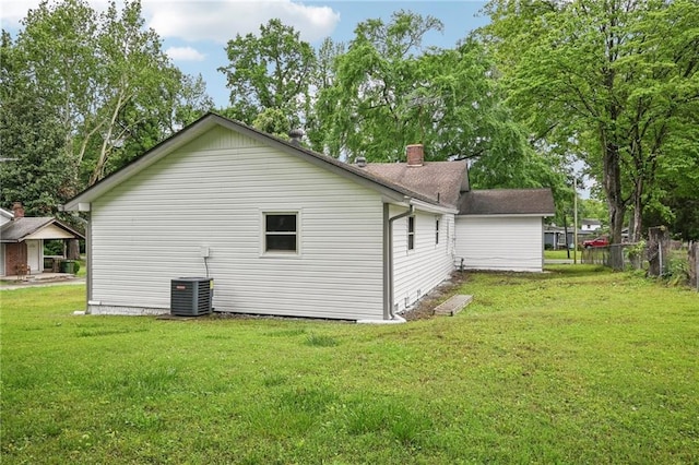view of property exterior with a lawn, central air condition unit, and a chimney