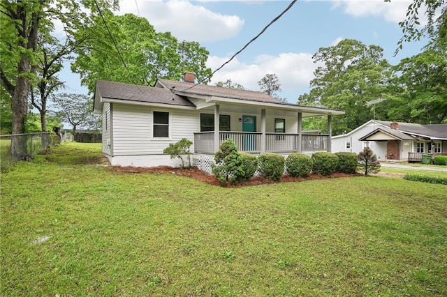 rear view of property with a porch, fence, a yard, and a chimney