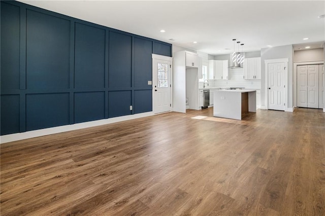 unfurnished living room featuring sink and hardwood / wood-style floors