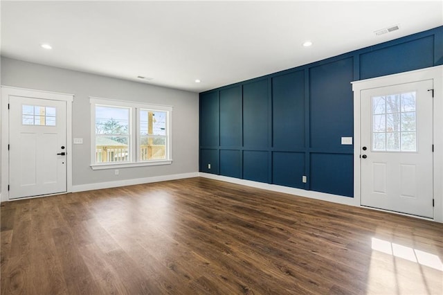 foyer featuring recessed lighting, dark wood-style flooring, visible vents, and a decorative wall