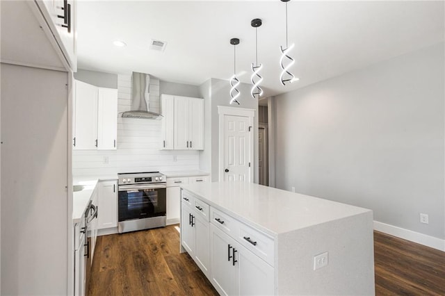 kitchen featuring white cabinets, wall chimney exhaust hood, a center island, and electric range