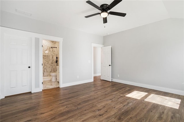 unfurnished bedroom featuring lofted ceiling, connected bathroom, visible vents, baseboards, and dark wood-style floors