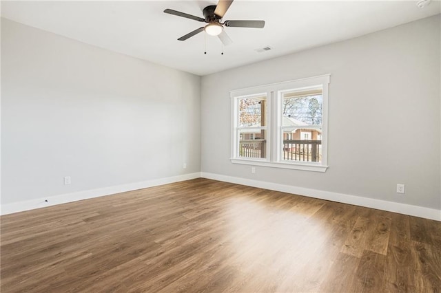 unfurnished room featuring visible vents, ceiling fan, baseboards, and wood finished floors