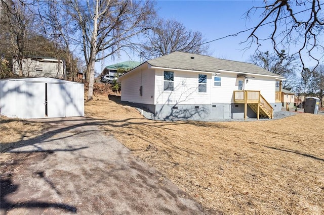 rear view of house with a storage shed