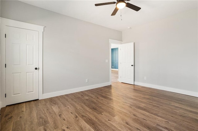 unfurnished bedroom with a ceiling fan, baseboards, and wood finished floors