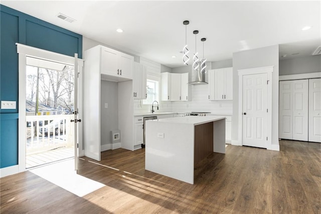 kitchen featuring a center island, white cabinets, light countertops, and decorative light fixtures