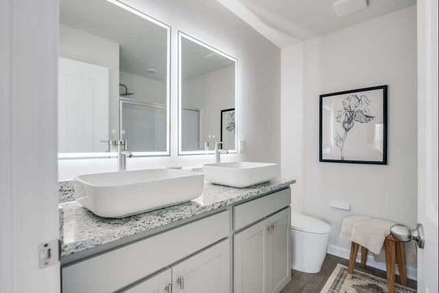 235 Ivey Ter, Temple, GA 30179 - full bathroom featuring toilet, double vanity, wood finished floors, and baseboards
