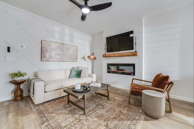 235 Ivey Ter, Temple, GA 30179 - living room featuring a ceiling fan, wood finished floors, baseboards, and a glass covered fireplace