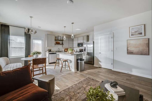 235 Ivey Ter, Temple, GA 30179 - living area with light wood finished floors, baseboards, and a chandelier
