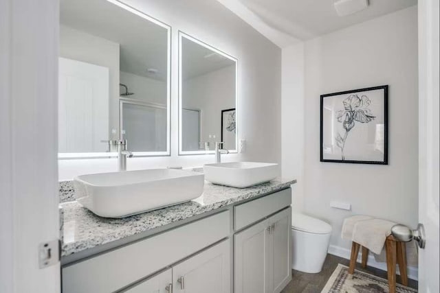 235 Ivey Ter, Temple, GA 30179 - full bathroom featuring toilet, double vanity, wood finished floors, and baseboards