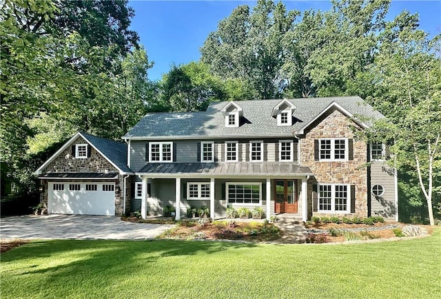 view of front of property featuring a porch, a front yard, and a garage