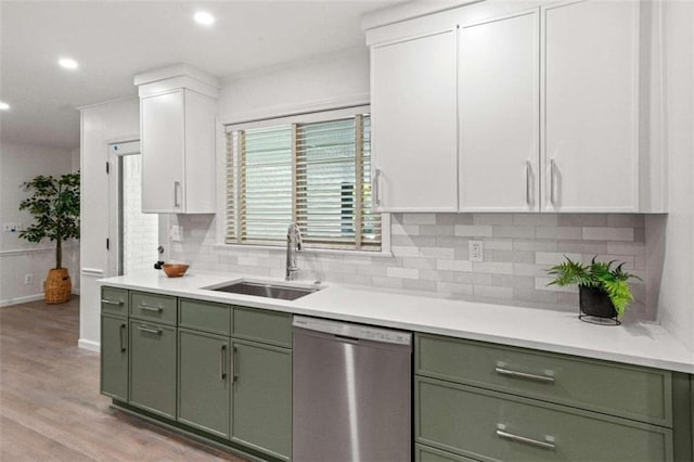 kitchen featuring tasteful backsplash, white cabinetry, light wood-type flooring, dishwasher, and sink