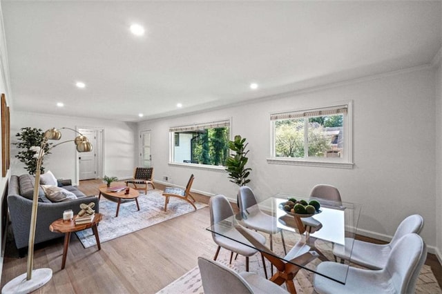 dining space featuring crown molding and light wood-type flooring