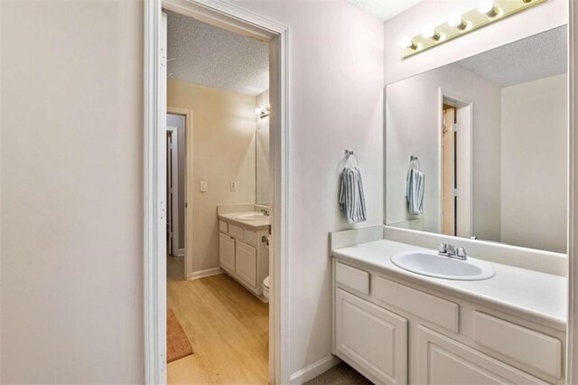 50 Emerald Hills Ln, Newnan, GA 30263 - bathroom with a sink, two vanities, a textured ceiling, and wood finished floors